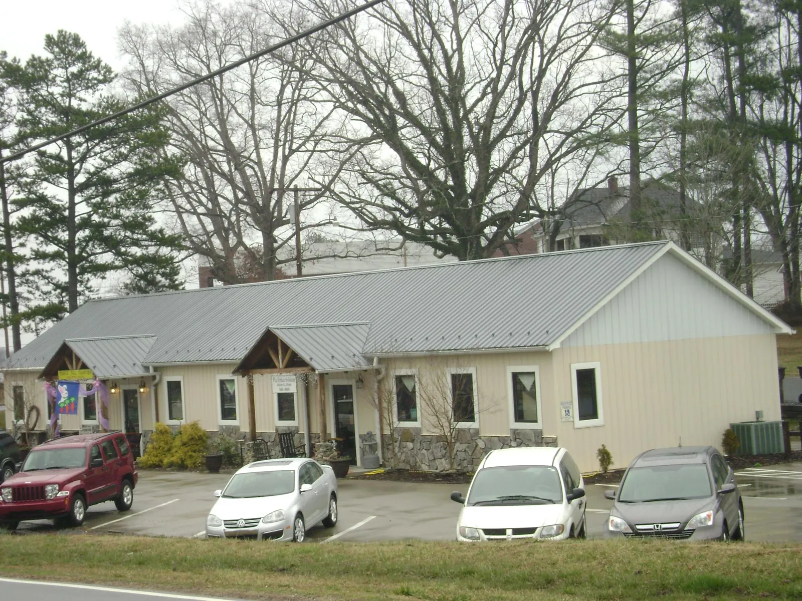 Gray metal roof with timber entry brackets on a small commercial building in Winamac