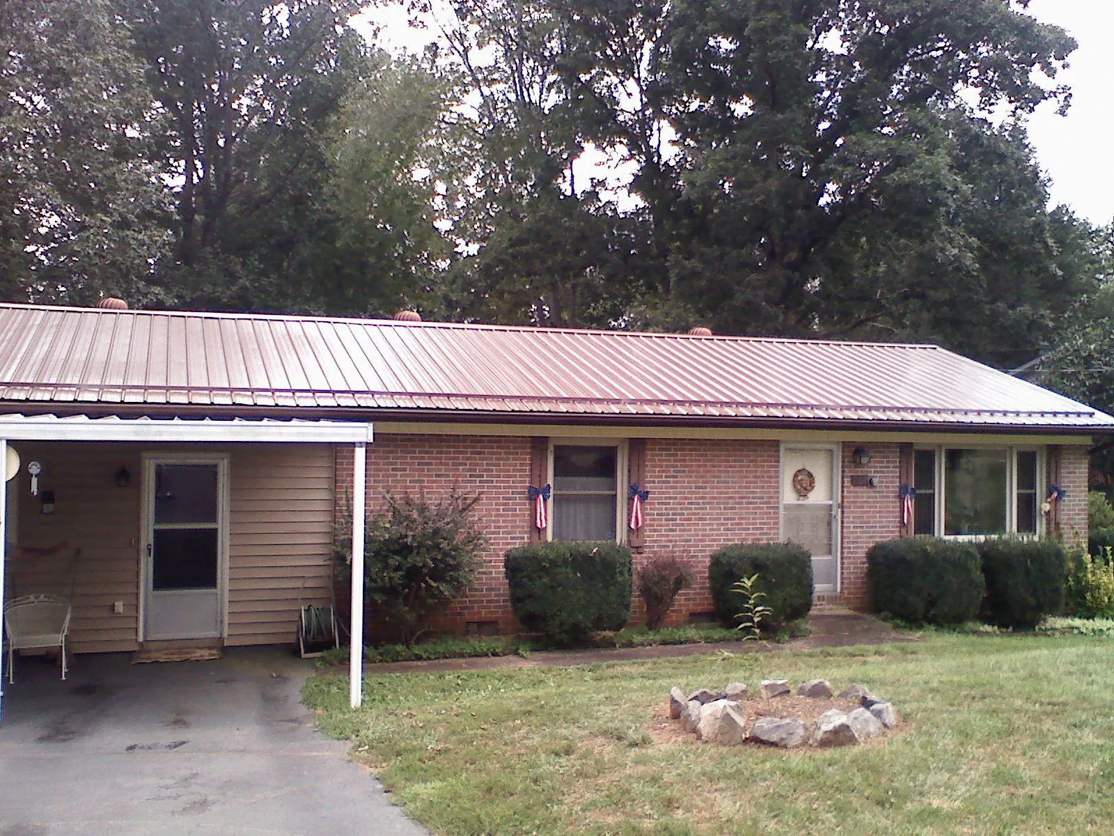 Bronze metal roof and carport on a brick ranch home — Roof Repair work by our crew in Winamac